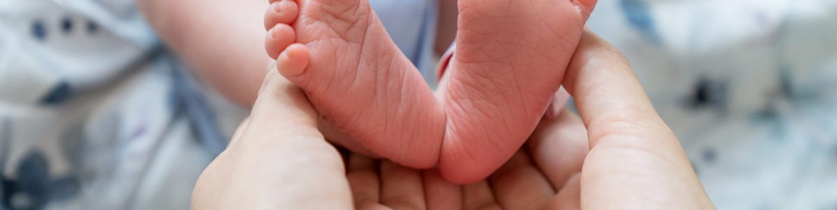 Stopy noworodka w dłoniach mamy